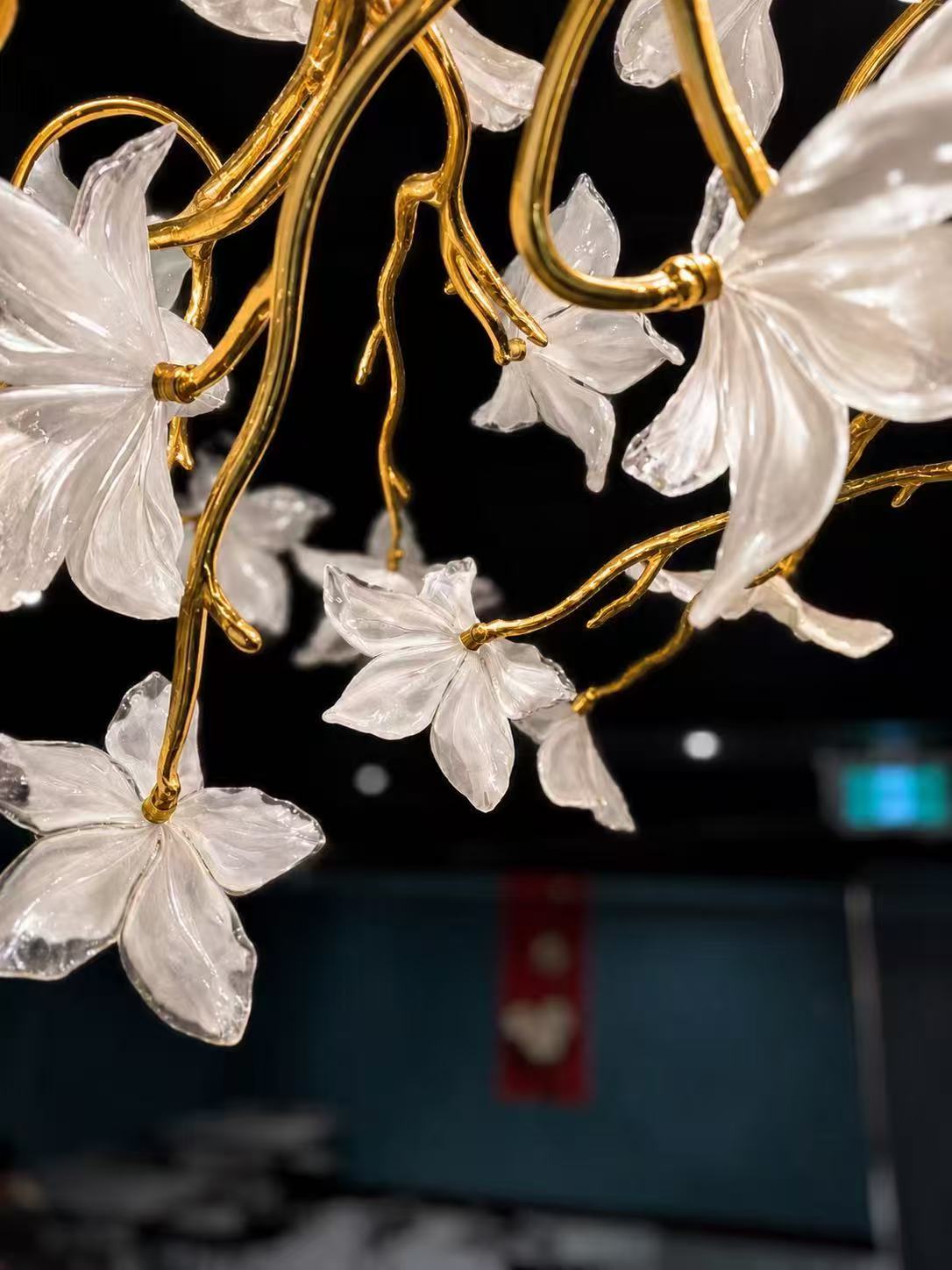 Hand formed glass flowers on golden branches above the SUMU dining room