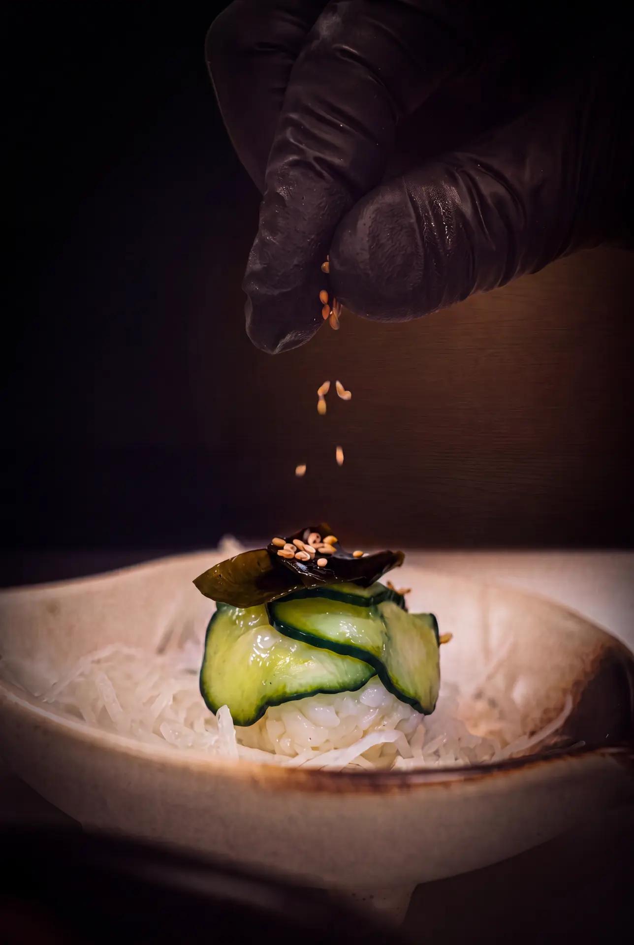 Toasted sesame falling over chilled cucumber and rice